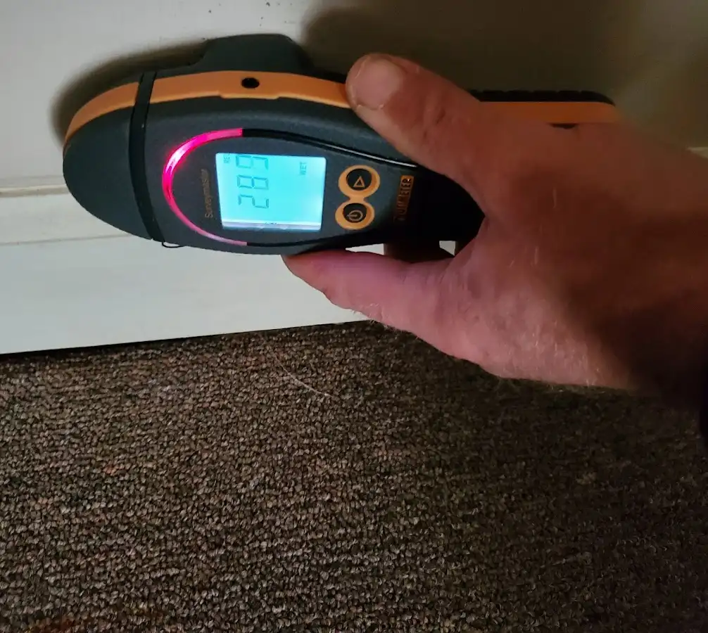Moisture detection at baseboard during Storm Damage Restoration in Cambria